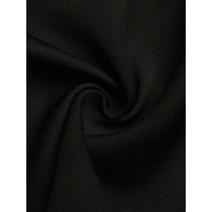 Detail of premium black textured woven fabric showing dense diagonal weave and elegant drape