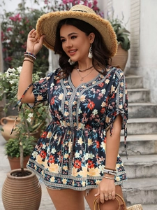 Detailed close-up of V-neckline with ethnic trim and floral print on summer blouse