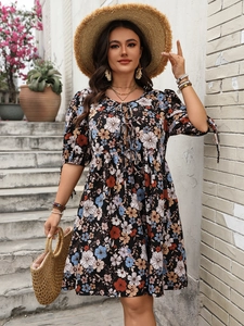 Dettaglio di un abito boho floreale con scollatura stringata e fiocchi sulle maniche