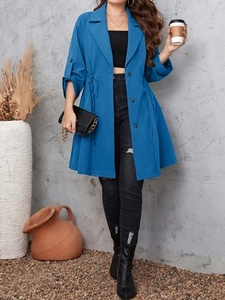 Close-up of blue longline trench coat with waist drawstring and adjustable button cuffs