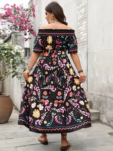Détail de la robe longue à épaules dénudées avec motif tournesol et ourlet à volants
