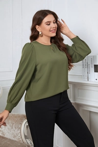 Detail of dark green chiffon blouse featuring a round neck with V-cut and lantern sleeves