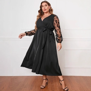 Abito nero taglie forti con scollo a V, maniche in tulle ricamate e cintura in vita coordinata