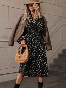 Detail of floral V-neck dress with leather jacket and gold chain bag accessory
