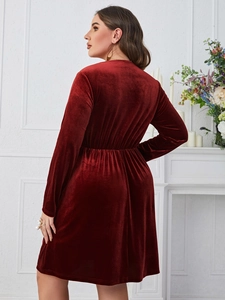 Close-up of elegant burgundy velvet dress showing high waist pleated details and soft texture