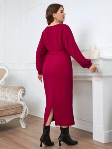Detail of elegant magenta long-sleeve dress featuring back slit and fabric waist belt