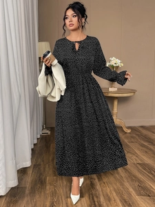 Detail of long sleeves with ruffled cuffs on a black polka dot plus size maxi dress