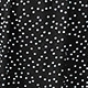 Close-up detail of classic white polka dot pattern on black plus size dress fabric