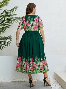 Détail de l'imprimé floral tropical et de la taille ajustée sur la robe verte en A