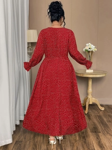 Rear view of a long red polka dot dress featuring elegant ruffled cuffs and a high waist