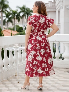 Back view of a red floral midi dress with ruffle sleeves and waist belt in a resort setting
