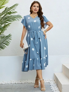 Detail of V-neck wrap dress in blue with white polka dots and ruffle hem sleeve design