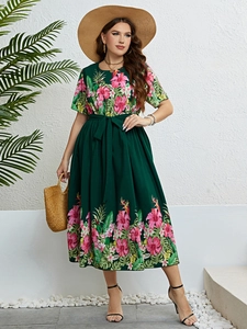 Détail de l'imprimé floral tropical sur robe d'été vert foncé avec hibiscus et palmiers
