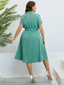 Detail of mint green shirt dress showing vertical pinstripe texture and waist tie
