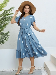 Detail of blue polka dot dress featuring a V-neckline and ruffled hemline for summer