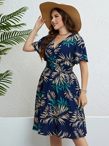 Detailed view of summer V-neck dress with tropical leaf print and smocked elastic waist