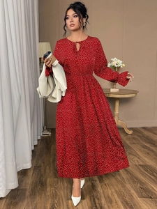 Detail of red polka dot maxi dress with elastic cuffs and decorative neck tie-up