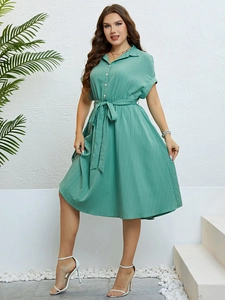 Detail of the waist tie and button closure on the green short sleeve summer midi dress