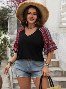 Close-up of V-neck top with colorful striped raglan sleeves and ruffled cuff details