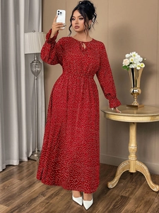 Close-up of the elegant red polka dot maxi dress featuring ruffle sleeves and a belted waist
