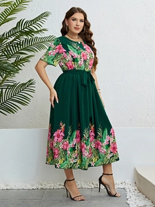 Détail de la robe d'été verte avec imprimé tropical et ceinture à nouer à la taille