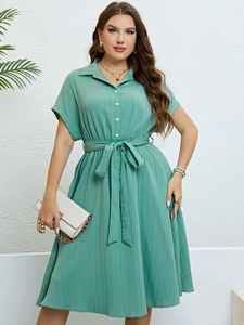 Detail of green shirt dress with vertical pleated texture and matching waist tie