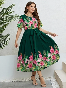 Détail de la robe d'été verte avec imprimé floral tropical et ceinture à nouer