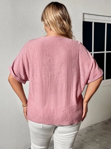 Detail of pink linen V-neck shirt featuring crushed texture and loose fit back view