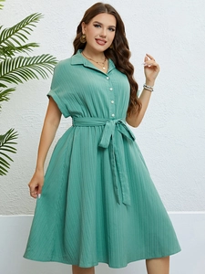 Close-up of the light green shirt dress showing vertical striped texture and waist tie