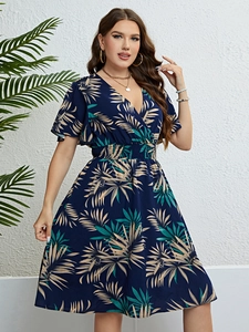 Detail of V-neck summer dress with tropical palm leaf pattern and cinched waist