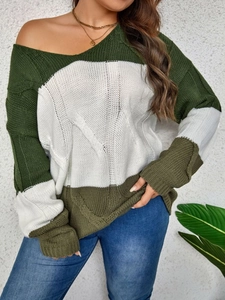 Detail of the green and white color block cable knit texture on a cozy winter sweater