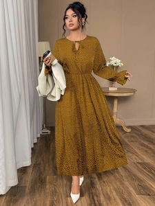 Detail of ginger yellow polka dot maxi dress featuring bell sleeves and tie-up neckline