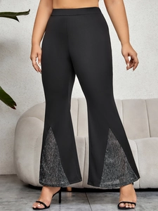 Detail von schwarzen High-Waist-Schlaghosen mit silbernen Pailletten am Schlitzsaum