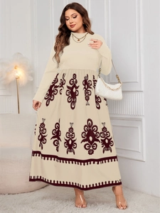 Detail of bohemian ethnic pattern on off-white high-waisted maxi dress with long sleeves