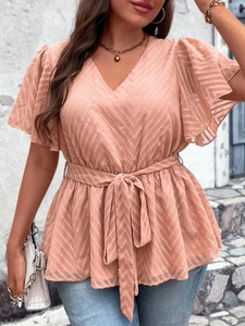 Detailed view of coral pink V-neck top with chevron texture and ruffle sleeves