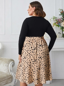 Detail of high-waist patchwork dress featuring leopard print skirt and black long sleeves