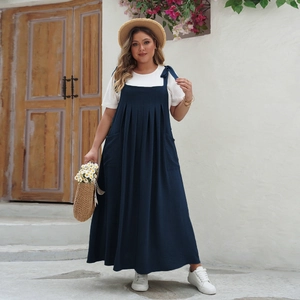 Detail of plus size navy blue overall dress with adjustable bow straps and white t-shirt