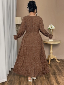 Macro detail of brown polka dot maxi dress featuring elegant ruffle cuffs and long sleeves