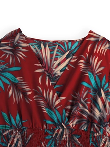 Detailed view of the V-neckline and elastic smocked waist on this tropical print dress