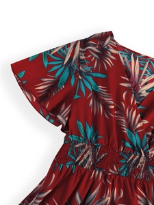 Detail of V-neckline and smocked waist on red tropical leaf print summer dress