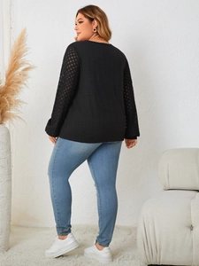 Rear view of black long sleeve top featuring intricate lace patchwork on the sleeves