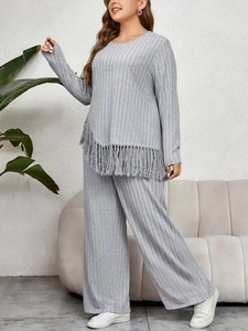 Detail showing the gray ribbed knit fabric texture and asymmetrical tassel hem design