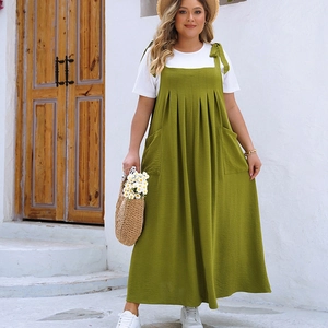 Detail of green plus size pleated overall dress with tie straps and side pockets