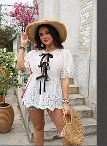 Haut blanc en broderie anglaise avec trois nœuds en satin noir et manches bouffantes
