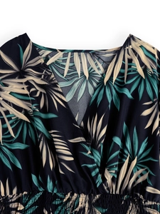 Detail of V-neckline and elastic smocking on tropical palm leaf print summer dress