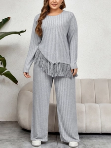 Detailed view of the textured grey ribbed fabric and fringe tassels on the top hem