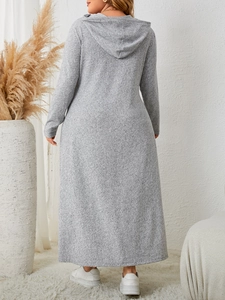 Rear view of a plus size hooded maxi dress in grey knit fabric within a cozy home setting