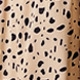Detailed macro view of beige fabric featuring black polka dot and animal print patterns
