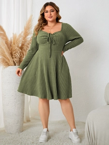 Detailed view of dark green rib-knit texture and square neckline with a tie on a plus-size dress
