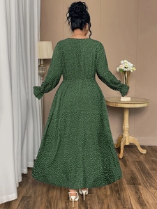 Detail of plus size dark green maxi dress with white polka dots and flared long sleeves
